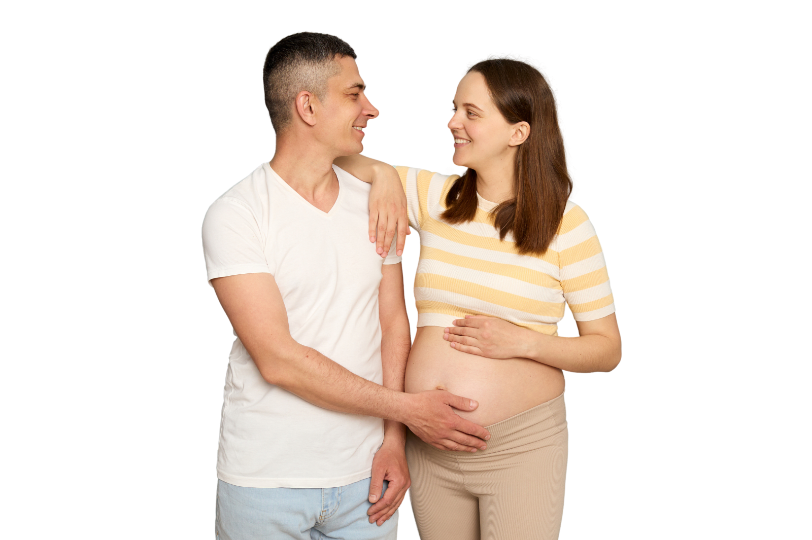 happy pregnant couple smiling at each other with man's hand on woman's belly.