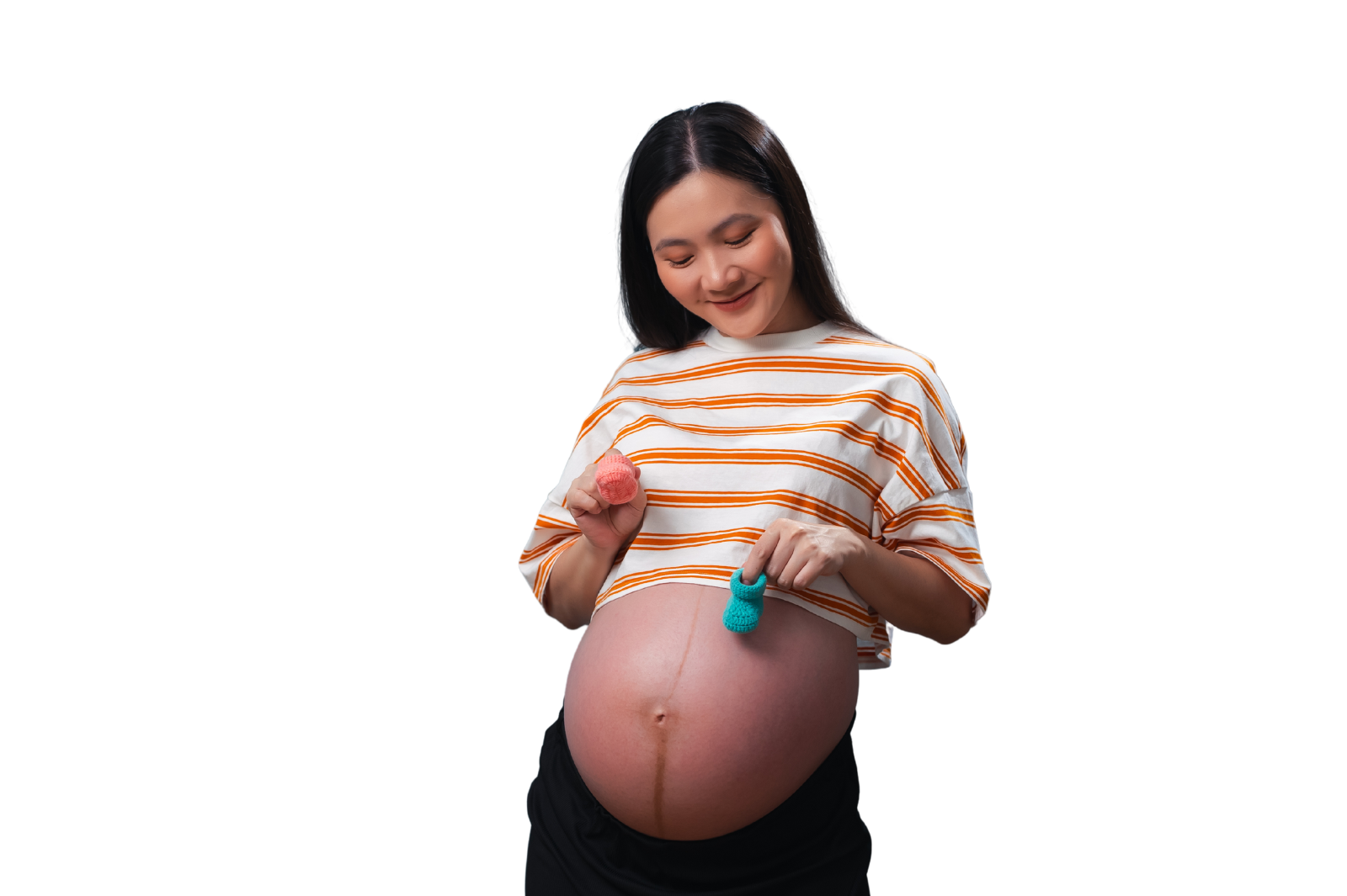 Pregnant woman with baby boots in hand looking lovingly at pregnant belly.