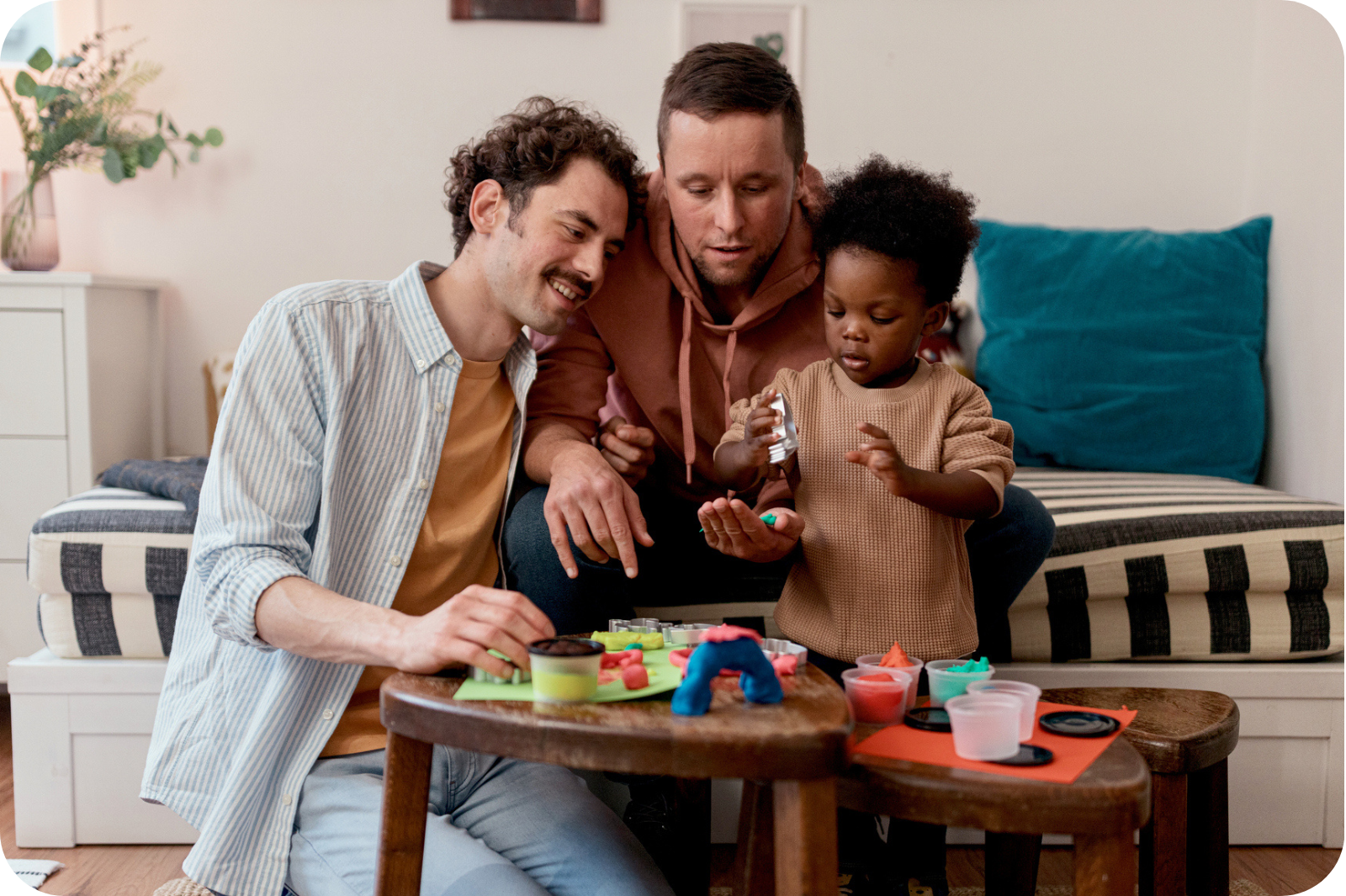 Couple playing with adopted child playing with toys and blocks.